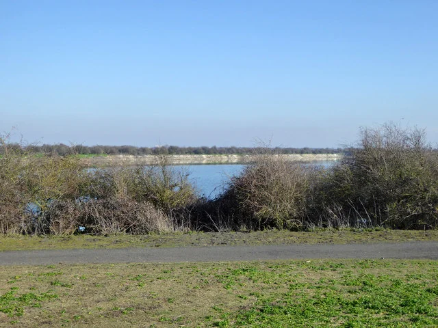 A lagoon beyond scrub and a path at Cliffe Pools