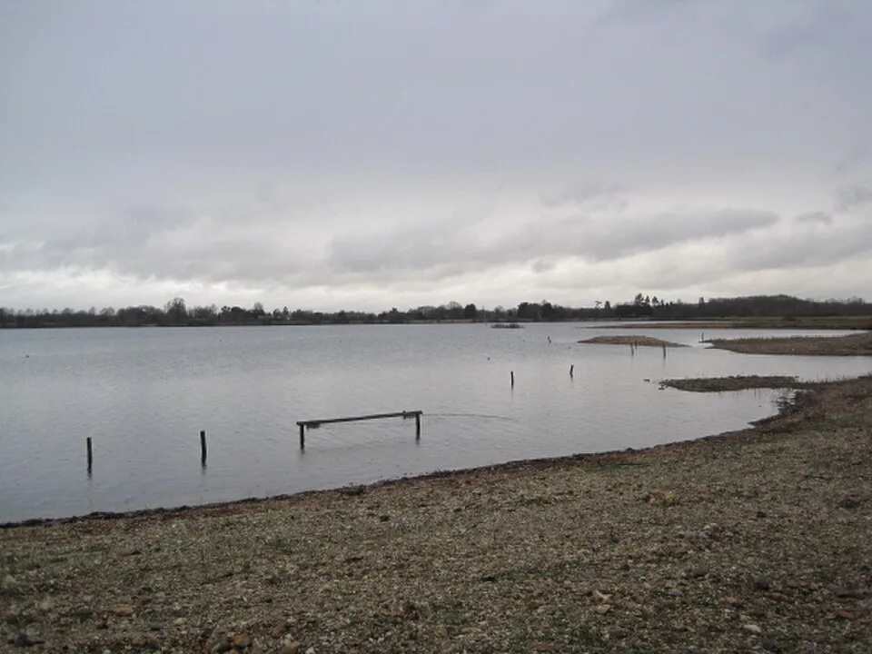 Ibsley Water viewed from Tern Hide at Blashford Lakes, with exposed shore and distant trees