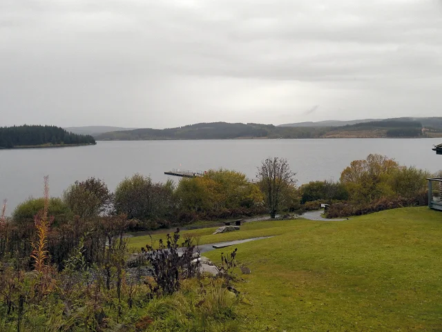 Kielder Water seen from Tower Knowe Visitor Centre, with trees and a jetty in the foreground
